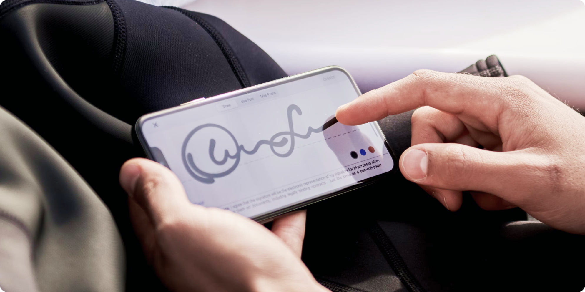 스마트폰 화면에 전자 서명을 입력하는 사람의 모습